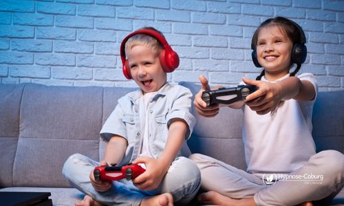 Kinder halten einen Spielecontroller und blickt nachdenklich – Symbol für Spielsucht und den Weg zu neuer Selbstkontrolle durch Hypnose.